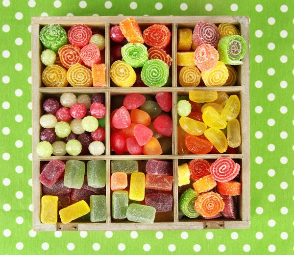 Multicolor candies in wooden box, on color background — Stock Photo, Image