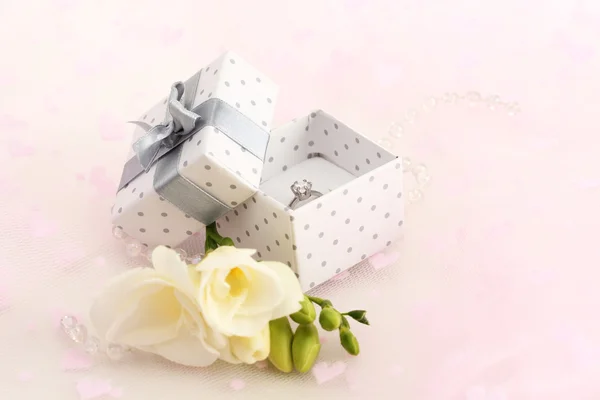 Beautiful box with wedding ring and flower on pink background — Stock Photo, Image