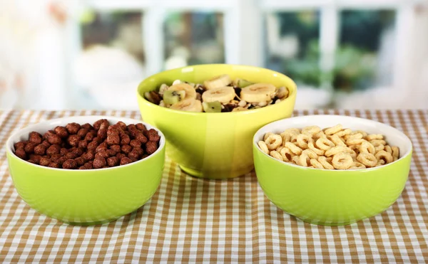 Cereais deliciosos e saudáveis em tigelas na mesa no quarto — Fotografia de Stock