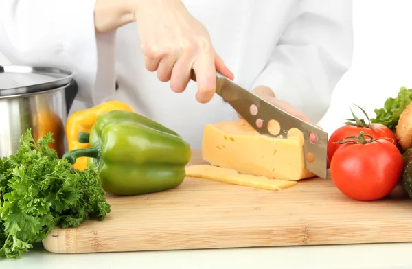 Weibliche Hände schneiden Käse, isoliert auf weiß — Stockfoto