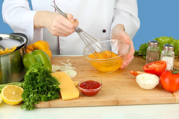 Female hands blending eggs in glass bowl — Stock Photo, Image