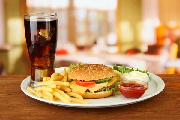 patates kızartması ve parlak zemin üzerine soğuk içecek ile lezzetli peynirli burger