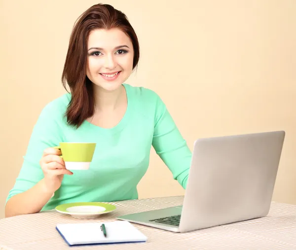 Gyönyörű fiatal nő dolgozik laptop-ra könnyű háttér — Stock Fotó