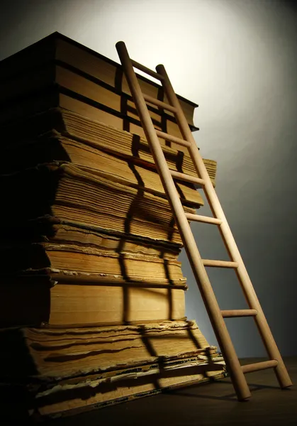 Gamla böcker och trä stege, på grå bakgrund — Stockfoto