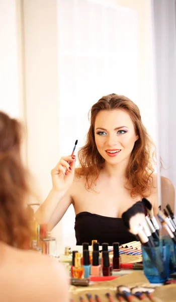 Jeune belle femme faisant maquillage près du miroir — Photo