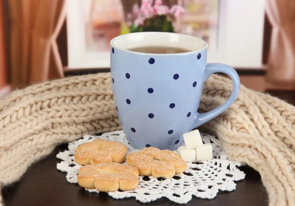 Cup of tea with scarf on table in room — Stock Photo, Image