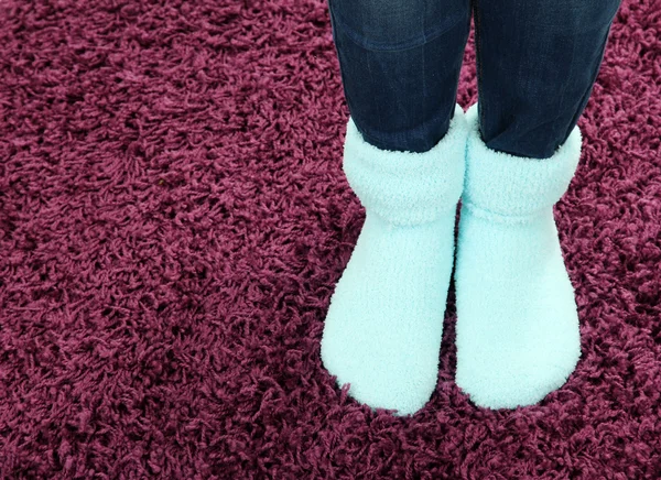 Female legs in colorful socks on color carpet background — Stock Photo, Image