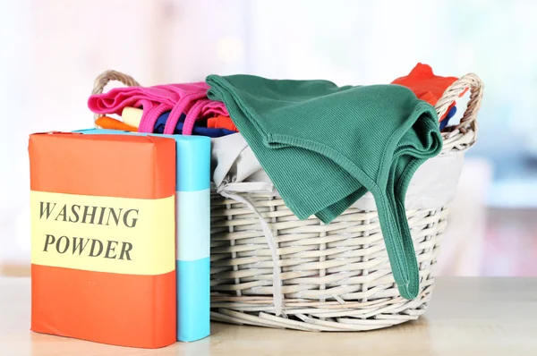 Clothes in wooden basket on table in room — Stock Photo, Image