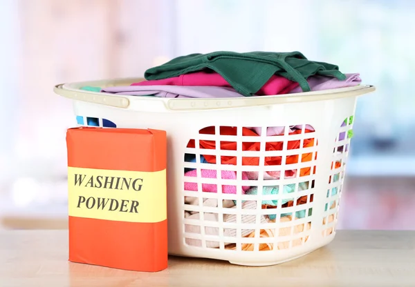 Clothes in plastic basket on table in room — Stock Photo, Image