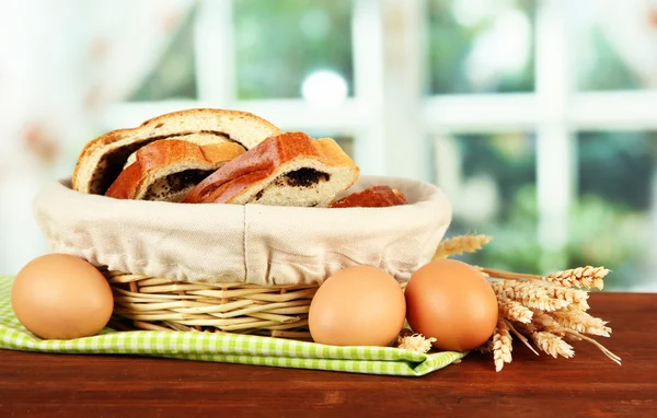 Loaf with poppy seed in wicker basket, on bright background — Stock Photo, Image