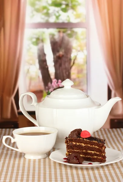 Teiera, tazza di tè e deliziosa torta sullo sfondo della finestra — Foto Stock