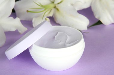 kozmetik krem ve mor zemin üzerine güzel zambak