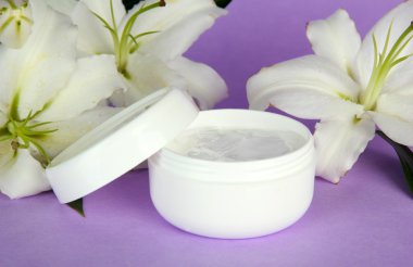 kozmetik krem ve mor zemin üzerine güzel zambak