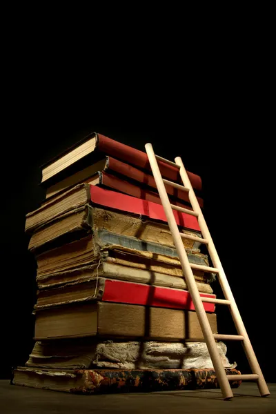 Old books and wooden ladder, on black background — Stock Photo, Image