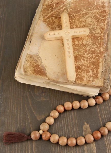 Bibel, Rosenkranz und Kreuz auf Holztisch in Großaufnahme — Stockfoto