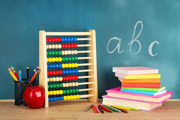 Juguete ábaco, libros y lápices en la mesa, en el fondo del escritorio de la escuela —  Fotos de Stock