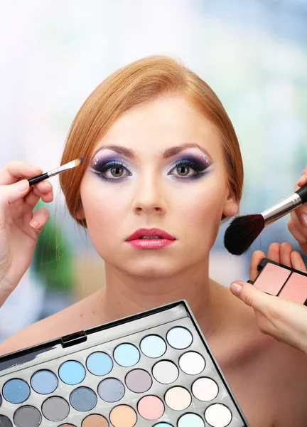 Portret van mooie jonge vrouw met het maken van make-up in beauty salon — Stockfoto