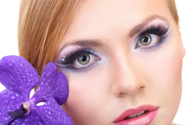 Retrato de una hermosa mujer joven con glamour maquillaje y flor, de cerca —  Fotos de Stock