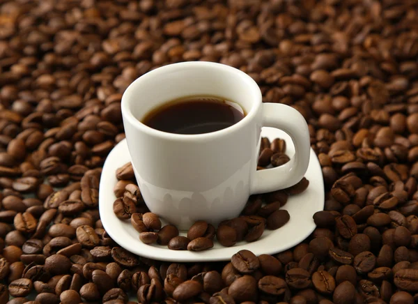 Šálek kávy na kávová zrna pozadí — Stock fotografie
