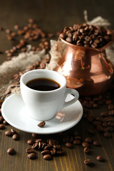 Csésze kávé és a pot a fából készült háttér — Stock Fotó