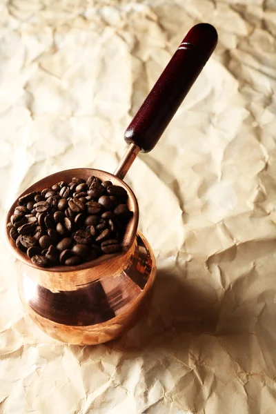 Panela de café com grãos de café no fundo bege — Fotografia de Stock