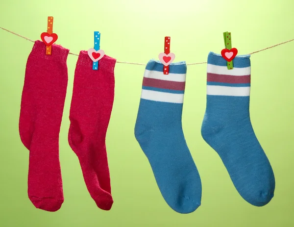 Calcetines coloridos colgando en el tendedero, sobre fondo de color —  Fotos de Stock