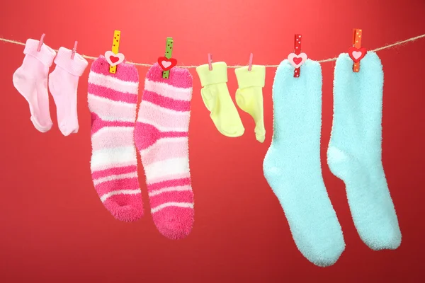 Kleurrijke sokken opknoping op/droogmolen, op een achtergrond met kleur — Stockfoto