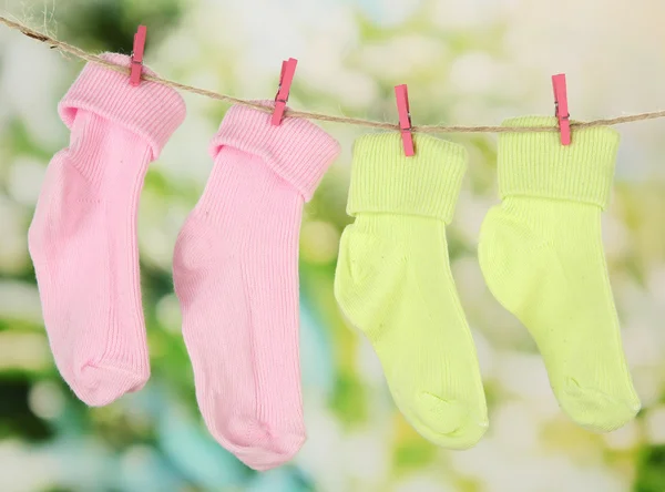 Calcetines coloridos colgando en el tendedero, sobre fondo brillante — Foto de Stock