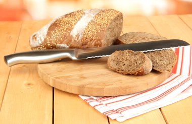 Susam ve doğrama kurulu ahşap masa üzerinde bıçak ile dilimlenmiş ekmek yakın çekim