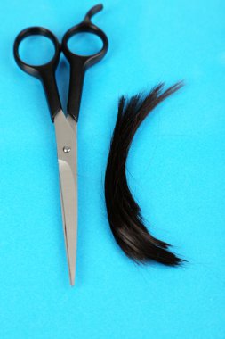 mavi zemin üzerine makasla kesilmiş saç parçaları