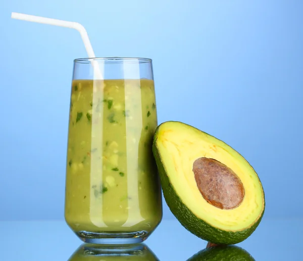 Nützliche frische Avocado und halbe Avocado auf blauem Hintergrund — Stockfoto