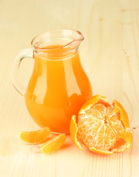 Jarra llena de jugo de mandarina, sobre fondo de madera —  Fotos de Stock