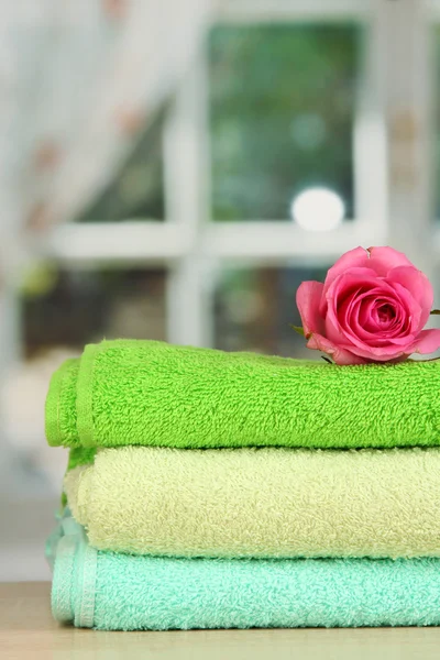 Stapel von Handtüchern mit duftender Blume auf Fensterhintergrund — Stockfoto