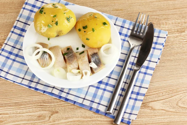 Plato de arenque y patatas en plato sobre mesa de madera primer plano —  Fotos de Stock