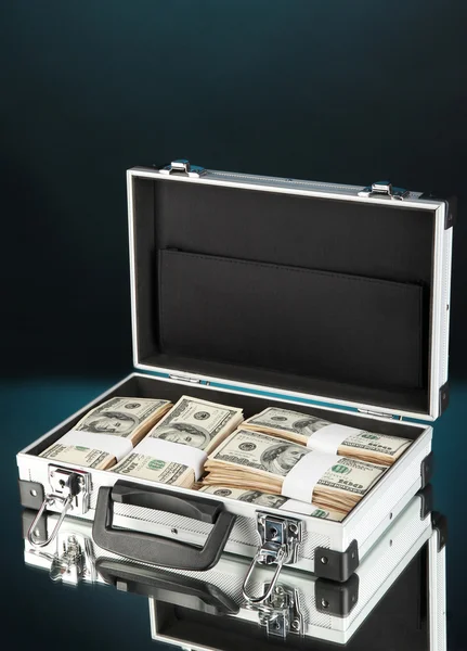 Suitcase with 100 dollar bills on dark color background — Stock Photo, Image