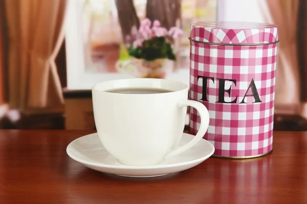 Jar och kopp te på bordet i rummet — Stockfoto