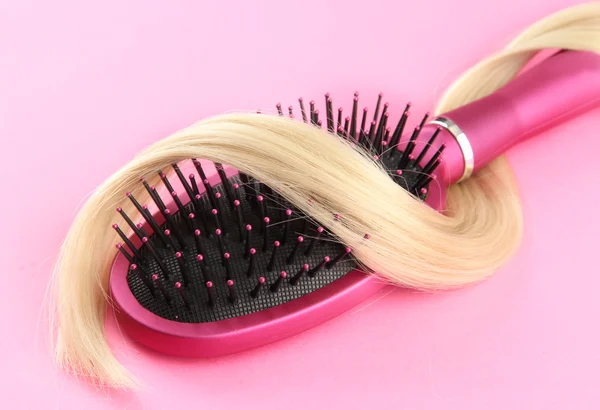 Comb brush with hair, on pink background — Stock Photo, Image