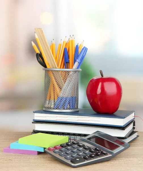 Material escolar com maçã vermelha na mesa de madeira — Fotografia de Stock