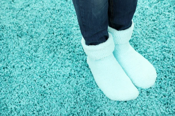 Pernas femininas em meias coloridas em fundo tapete de cor — Fotografia de Stock