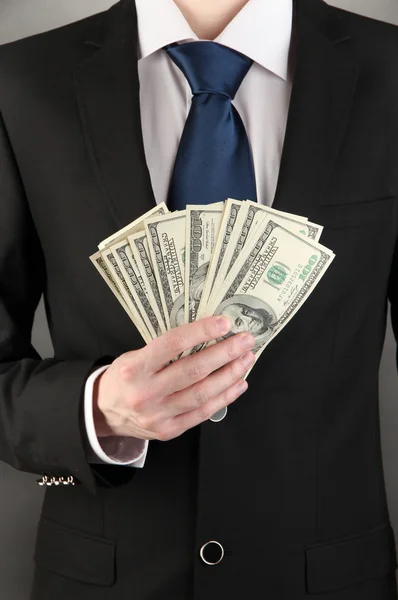 Business man holds lot of money on black background — Stock Photo, Image