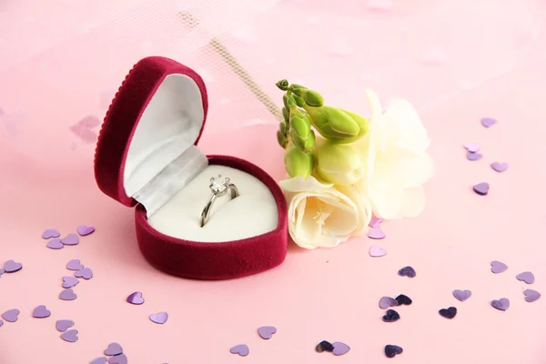 Beautiful box with wedding ring and flower on pink background — Stock Photo, Image