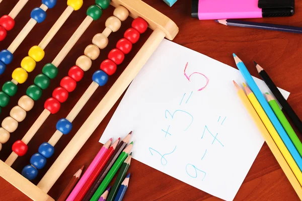 Toy abacus, note paper, pencils on bright background — Stock Photo, Image