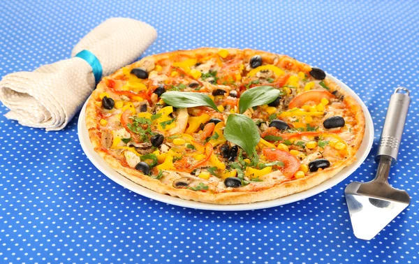 Tasty pizza on blue tablecloth close-up — Stock Photo, Image