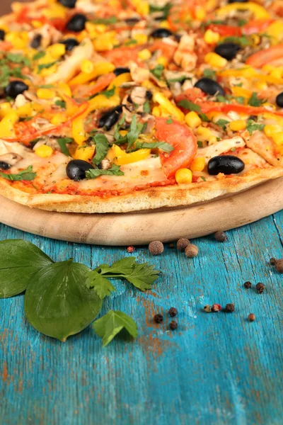 Ízletes pizza a közeli kék fa tábla — Stock Fotó