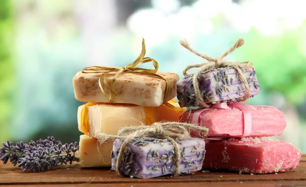 Natural handmade soap, on wooden table, on green background — Stock Photo, Image