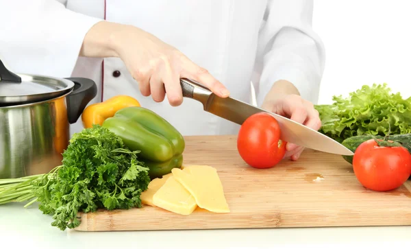 Mãos femininas cortando legumes, isolados em branco — Fotografia de Stock