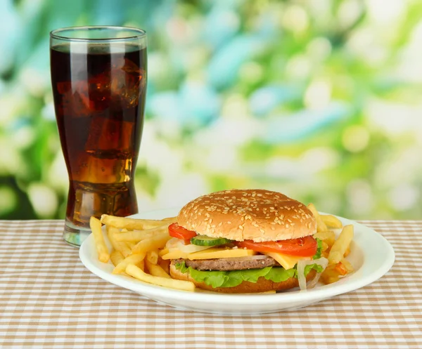 Savoureux cheeseburger aux pommes de terre frites et boissons froides, sur fond lumineux — Photo