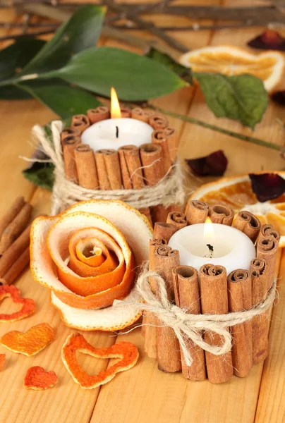 Rosa decorativa da casca de laranja seca e velas em chamas na mesa de madeira — Fotografia de Stock