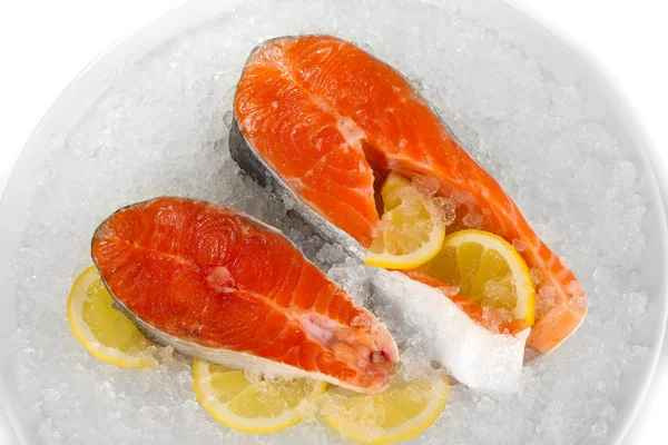 Pezzi di pesce rosso su ghiaccio in piatto isolato su bianco — Foto Stock