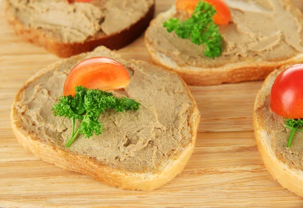 Fresh pate on bread on wooden board, close up — Stock Photo, Image